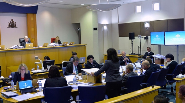 A crowded hearing room with Commissioners sitting in the distance in Darwin