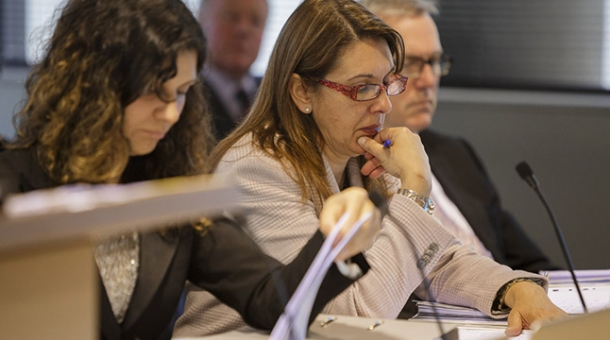 Unidentified members of the legal team sitting at a bench in the hearing room