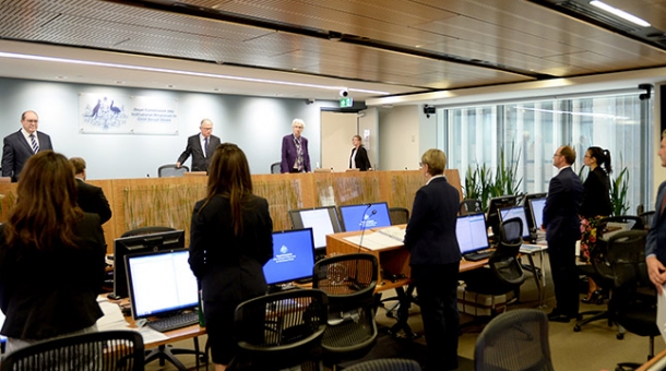 Hearing room standing as Commissioners enter the room
