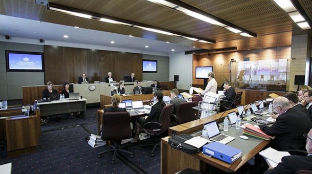 A hearing room with legal staff and commissioners sitting at a bench in the distance