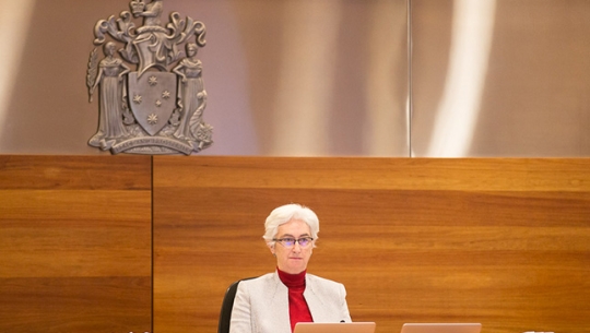 Justice Jennifer Coate sitting at a bench