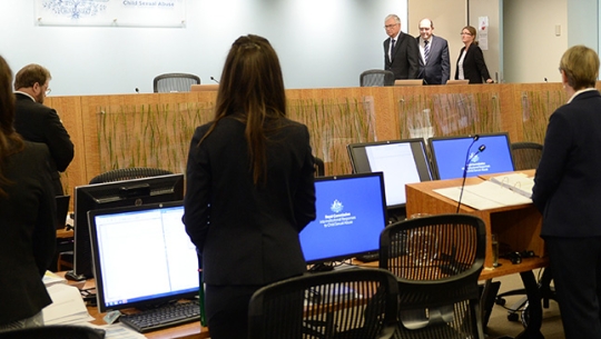 Hearing room standing as Commissioners enter the room