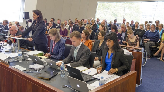 Counsel Assisting, Sophie David SC addresses Commissioners with crowded hearing room behind her